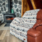 Couverture de laine boho sur un divan en cuir devant un feu de foyer au chalet